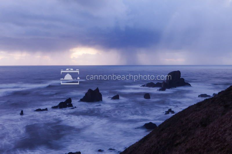 Rain clouds gather off the west coast over the stormy pacific ocean at the Sea Lion Rocks in Ecola State Park.